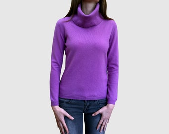 Könnte beinhalten: Ein lilafarbener Rollkragenpullover mit langen Ärmeln.