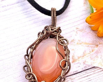 Carnelian gemstone wrapped in enamelled copper wire complete with black neck cord