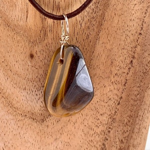 Golden Tigers Eye tumble-stone pendant on a sterling silver bail with black neck cord