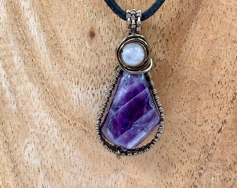 Amethyst with rose quartz focal stone, wrapped in enamelled copper wire, complete with black neck cord