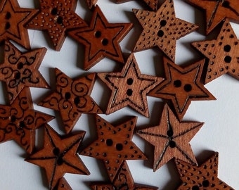 May include: A selection of star-shaped wooden buttons. The buttons are a warm brown colour, with etched details and two or four holes for sewing. Some stars have dotted patterns, while others feature swirling designs.