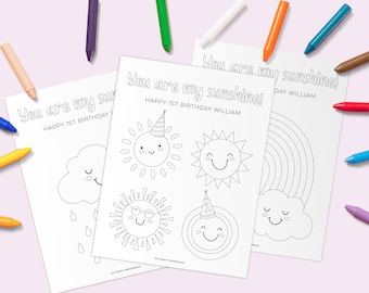 May include: Three black and white coloring pages with the text "You are my sunshine!" and "Happy 1st Birthday William". The pages feature a sun with a party hat, a sun with sunglasses, a sun with a number one party hat, a cloud with raindrops, and a rainbow.