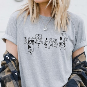 Lustig Hängende Katzen Shirt | Niedliches Katzen Lineup T-Shirt für Katzenliebhaber | Skurril Kitty Grafik T-Shirt | Unisex Katzen Humor Shirt | Katzen Mama Geschenk
