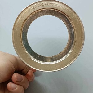May include: A silver-colored metal ring with a circular opening and the text "LT-50" engraved on the outer edge.