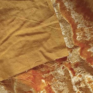 May include: A close-up of two pieces of fabric, one a smooth, golden yellow and the other a soft, fuzzy, golden yellow velvet.