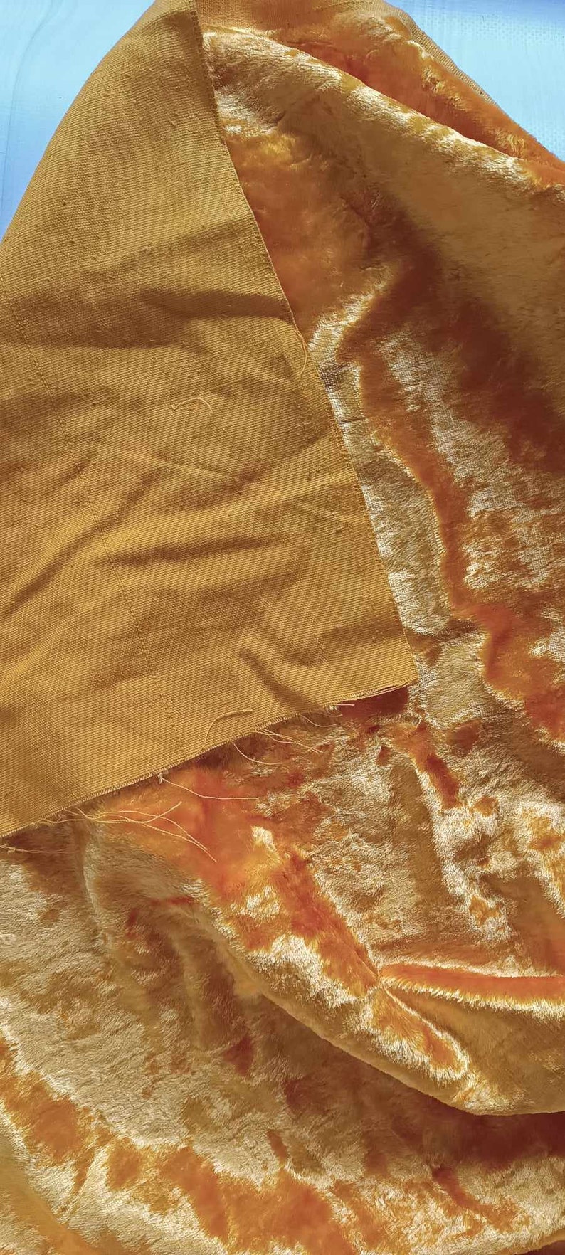 May include: A close-up of two pieces of fabric, one a smooth, golden yellow and the other a soft, fuzzy, golden yellow velvet.