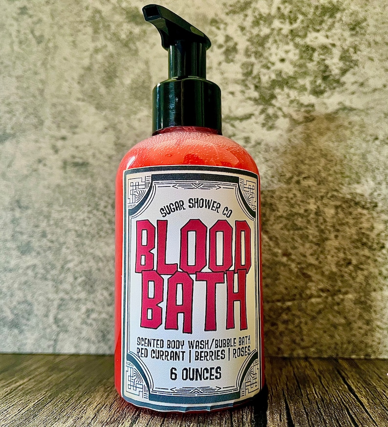 May include: A red bottle of body wash with a black pump top. The label reads "SUGAR SHOWER CO BLOOD BATH SCENTED BODY WASH/BUBBLE BATH RED CURRANT | BERRIES | ROSES 6 OUNCES".