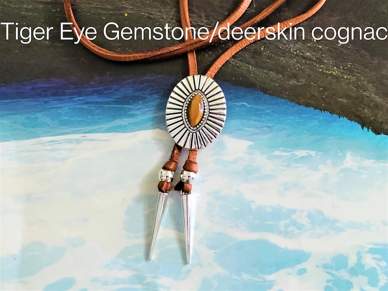 Western Bolo tie necklace for women girls, an Aztec style ancient silver metal oval slider flower Concho with a marquise shape tiger eye gemstone decoration slide over a 34 inch length saddle tan leather lace, silver spikes décor both leather ends