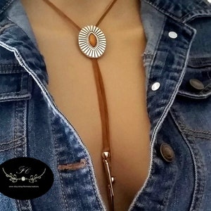 Western Bolo tie necklace for women girls, an Aztec style ancient silver metal oval slider flower Concho with a marquise shape tiger eye gemstone decoration slide over a 34 inch length saddle tan leather lace, silver spikes décor both leather ends