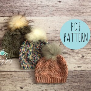 May include: Three crocheted hats with faux fur pom poms in green, pink, and multi-colored yarn. The hats are arranged on a wooden surface with a blue circle that says "PDF PATTERN".