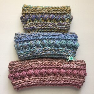 Puede incluir: Tres diademas de crochet en diferentes colores. La diadema superior es una mezcla de morado, azul y verde. La diadema del medio es una mezcla de azul, verde y gris. La diadema inferior es una mezcla de rosa y marr&oacute;n. Las tres diademas tienen un dise&ntilde;o texturizado y abultado.
