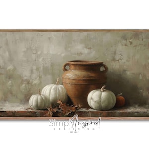 May include: A framed still life painting featuring a large brown earthenware pot with handles, three white pumpkins, and one small orange pumpkin. The background is a muted green and brown, with the text "Simply Inspired Design Co. EST.2017" at the bottom.