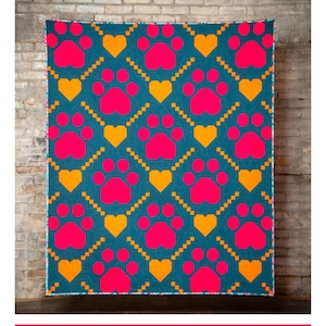 Peut inclure: Une couverture turquoise avec un motif répété d'empreintes de pattes roses vives et de cœurs orange. Le texte "Paw Prints on My Heart" est en haut. La bannière inférieure indique "Une couverture inspirée des chiens pour les amoureux des chiens !"