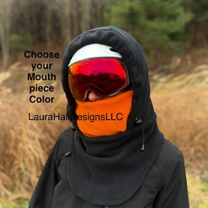 May include: Black fleece hood with an orange mouth piece and a white helmet with red mirrored goggles. The text "Choose your Mouth piece Color" and "LauraHallDesignsLLC" are visible on the image.