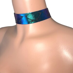 May include: A blue and green iridescent choker necklace with a scale pattern.