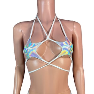 Puede incluir: Un top blanco de halter con un diseño de estrella plateada iridiscente y pantalones cortos a juego plateados iridiscentes.