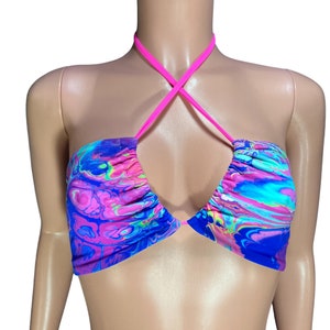 May include: A pink and blue halter top with a marbled pattern. The top has a criss-cross halter strap design.