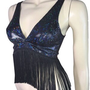 May include: A black crop top with a iridescent, glittery fabric and a fringe trim.