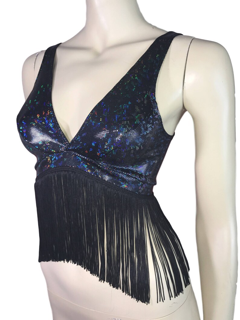 May include: A black crop top with a iridescent, glittery fabric and a fringe trim.