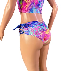 May include: Blue and pink marbled print shorts with a side lace-up detail. The shorts have a high-cut leg and a low rise.