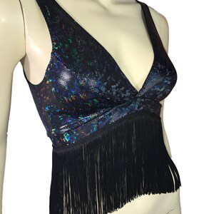 May include: A black crop top with a iridescent, glittery pattern and black fringe trim.