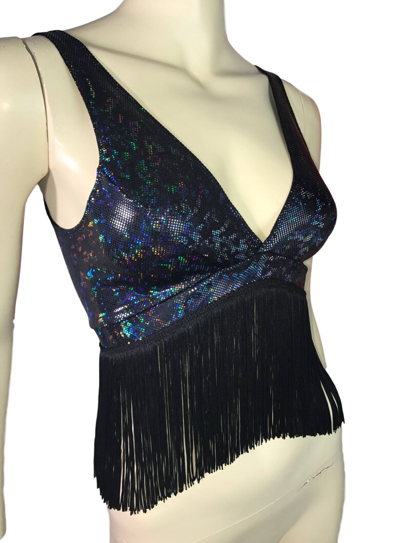 May include: A black crop top with a iridescent, glittery pattern and black fringe trim.