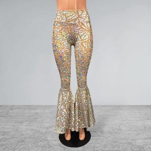 May include: Gold and iridescent bell bottom pants with a geometric pattern. The pants are made of a stretchy, comfortable fabric and have a high waist.