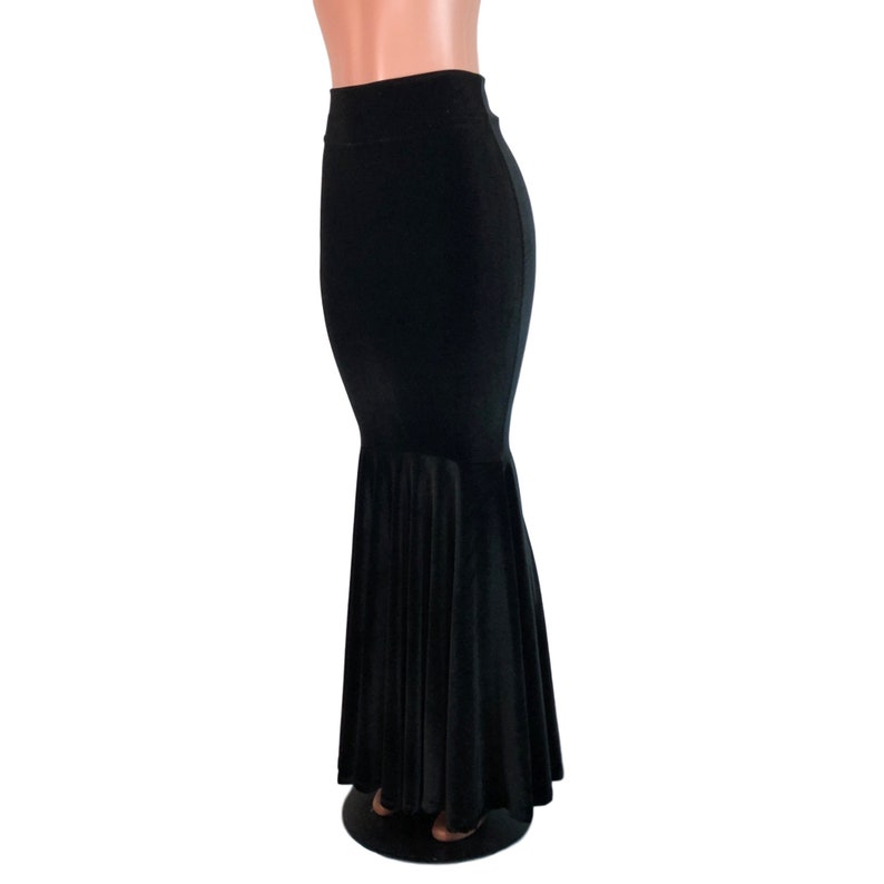 Peut inclure: Une jupe de sir&egrave;ne en velours noir avec une taille haute et un ourlet ample et &eacute;vas&eacute;.