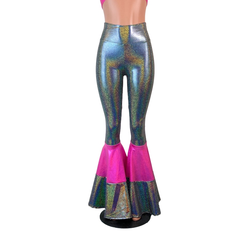 May include: High-waisted flared trousers with a silver iridescent fabric and a pink trim at the bottom of the legs.