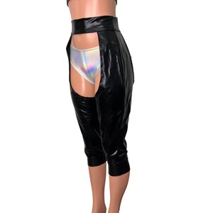 Puede incluir: Pantalones negros de imitaci&oacute;n de cuero con una abertura en el muslo en cada pierna. Los pantalones tienen cintura alta y una cintura ancha.