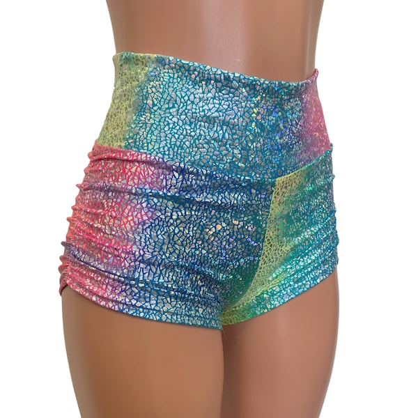 May include: High-waisted iridescent shorts with a rainbow pattern. The shorts are made of a shiny, textured fabric and have a high-cut leg.