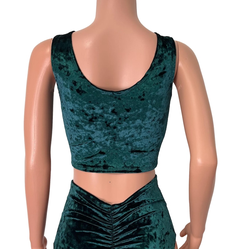 May include: A green velvet crop top and high-waisted shorts set. The top has a scoop neckline and the shorts have a high-waisted fit with a gathered detail in the back.