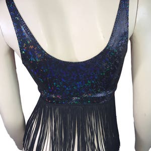 May include: Black iridescent crop top with a fringe trim. The top has a scoop neck and a sleeveless design.