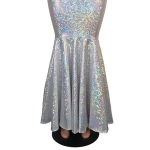 May include: A silver iridescent mermaid skirt with a flared bottom. The skirt is made of a stretchy, shiny fabric.