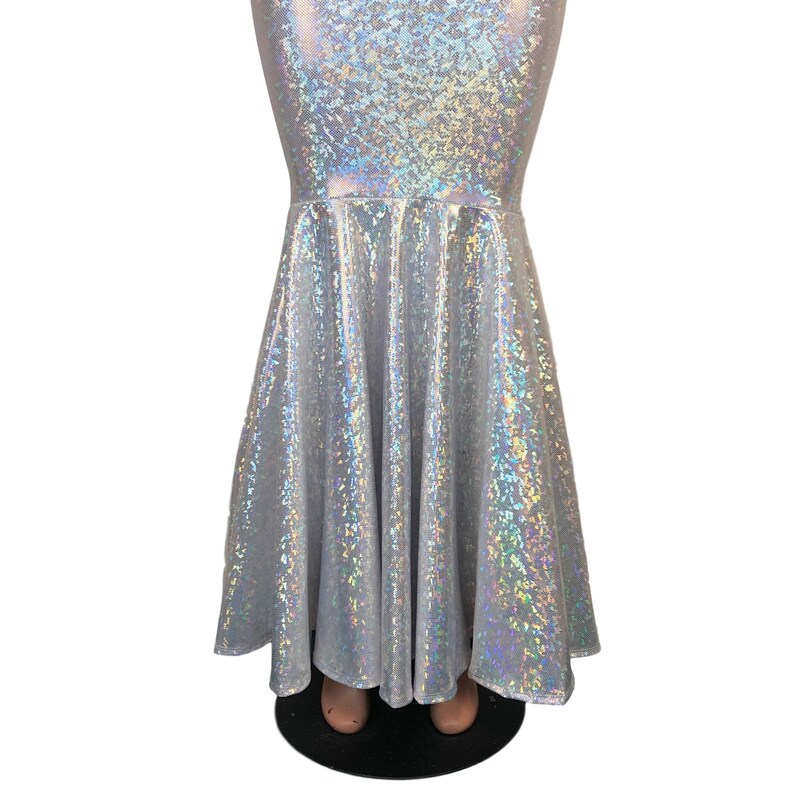 May include: A silver iridescent mermaid skirt with a flared bottom. The skirt is made of a stretchy, shiny fabric.