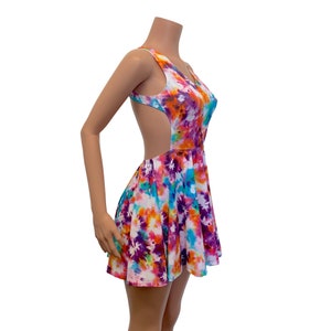 May include: A colorful tie-dye skater dress with a cutout back. The dress has a white background with orange, purple, blue, and pink tie-dye patterns.