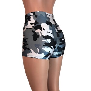 May include: High-waisted shorts in a camouflage print with black, white, and gray colors. The shorts are made of a shiny, stretchy fabric.