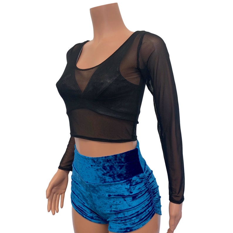 K&ouml;nnte beinhalten: Schwarzes, durchsichtiges, lang&auml;rmliges Crop-Top mit Rundhalsausschnitt und blauen Samt-Shorts.