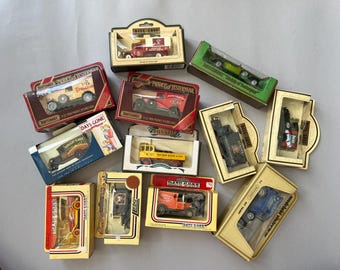 May include: A collection of eleven vintage die-cast toy vehicles in their original cardboard boxes, including various Matchbox Models of Yesteryear and Days Gone series trucks, vans, and cars in red, yellow, green, blue, and black colors.