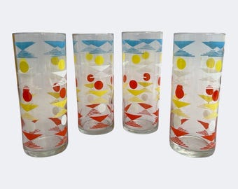 May include: Set of four vintage highball glasses. Each glass features a repeating pattern of blue triangles, yellow circles, red dots, and white triangles. The glasses are clear and cylindrical, perfect for serving cold beverages.