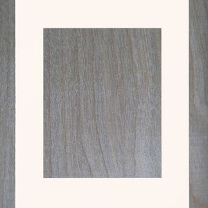 May include: A white picture frame with a thick white mat. The frame is on a wood background.