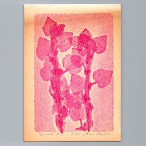 May include: A rectangular print on light beige paper featuring two vertical plant stems with broad, pointed leaves in vibrant magenta ink. The background has a fine horizontal line texture. Handwritten text at the bottom reads Weeds #3 8/35.