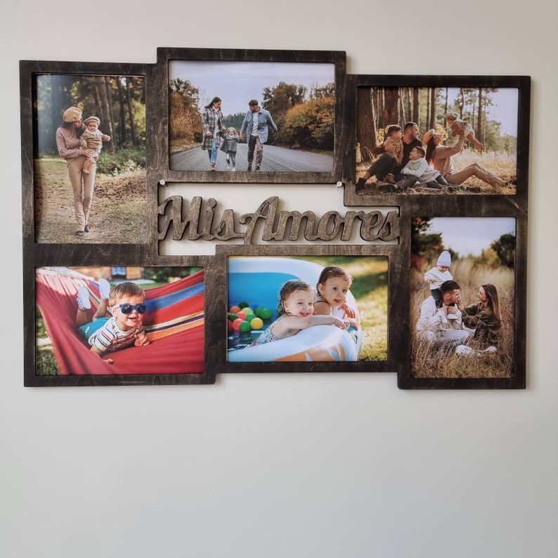 Pode incluir: Uma moldura de colagem de fotos em madeira castanho-escura com seis aberturas retangulares para fotografias. A moldura inclui um recorte central com o texto em cursivo "Mis Amores" num acabamento de madeira castanho-escura a condizer.