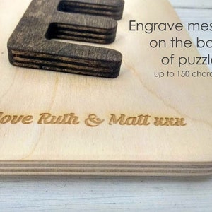 Pode incluir: Um quebra-cabe&ccedil;a de madeira com uma mensagem gravada no verso. A mensagem diz "Love Ruth & Matt xxx".