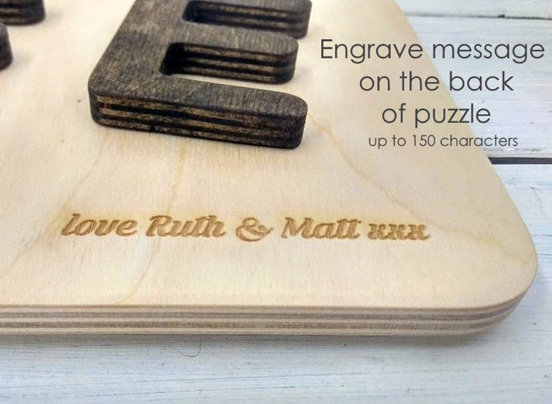 Pode incluir: Um quebra-cabe&ccedil;a de madeira com uma mensagem gravada no verso. A mensagem diz "Love Ruth & Matt xxx".