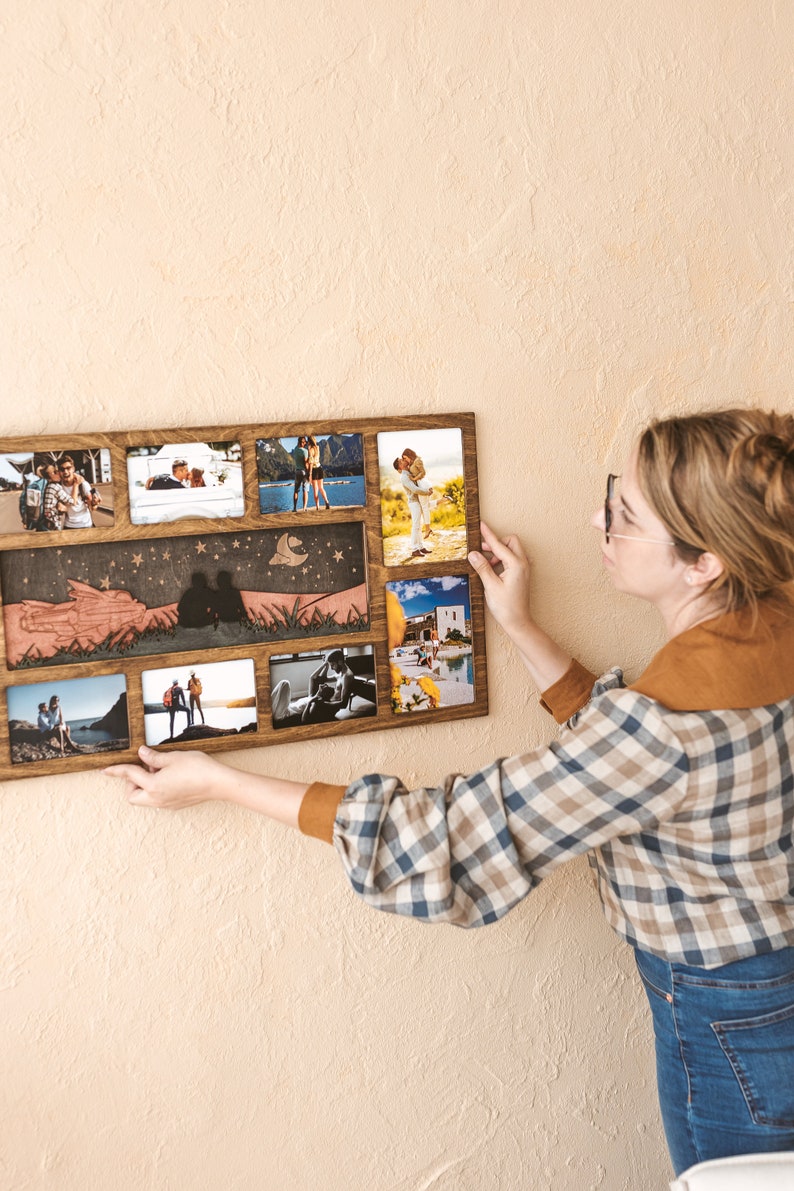 May include: A rectangular wooden collage photo frame featuring eight individual picture slots and a central horizontal panel with a laser-cut silhouette of two figures sitting on a hill under a starry night sky with a crescent moon.