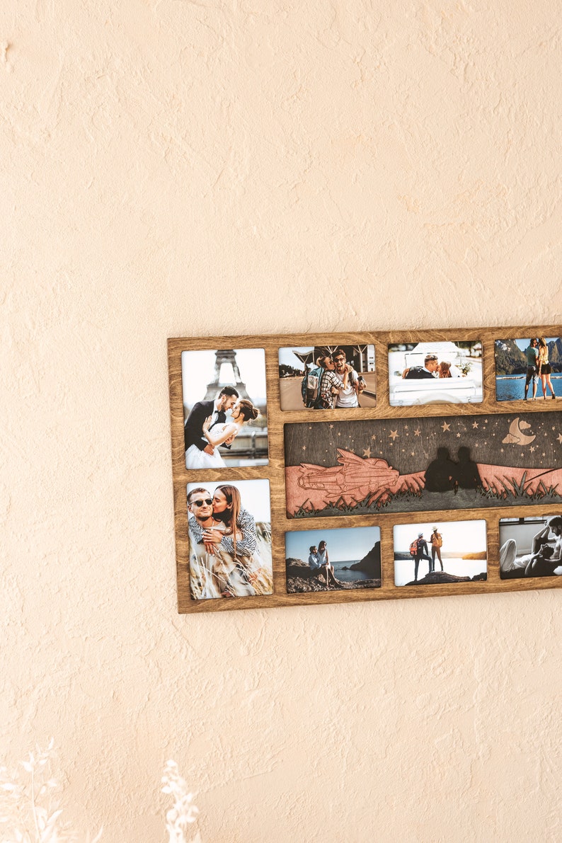 May include: A rectangular wooden collage photo frame featuring eight individual picture slots and a central horizontal panel with a laser-cut wooden silhouette of a couple sitting under a starry sky with a crescent moon and a small airplane.