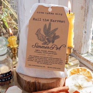 May include: A white muslin bag with a brown paper tag that reads "crow takes wing Hail the Harvest Simmer Pot Apple, Orange, Rosemary, Cinnamon, Clove and Ginger white Sage Pour contents into medium sized saucepan or crockpot filled with water. Bring to a boil and simmer on low. Let the aromatics fill your heart and home. Add water as needed to enjoy for hours. Not for consumption. www.crowtakeswing.com @crow.takes.wing"
