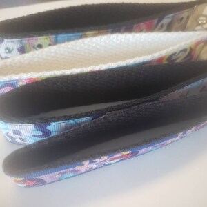May include: Three keychains with wrist straps. The straps are made of patterned ribbon with a black interior and a metal key ring. The patterns include a variety of colors, including blue, pink, and white.