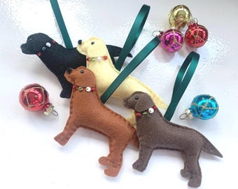 Può includere: Ornamenti a forma di cane in feltro nero, giallo, marrone e grigio, ciascuno con un collare decorativo e un nastro verde per appenderli. Sono presenti anche diversi ornamenti a sfera di vetro colorati, perfetti per le feste.
